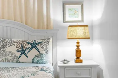 a bedroom with a bed and a lamp on a night stand at Beachfront, Ocean Views, Sleeps 6 , Hot tub in Panama City Beach