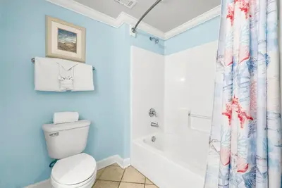 a bathroom with a toilet and a tub and a shower curtain at Beachfront, Ocean Views, Sleeps 6 , Hot tub in Panama City Beach