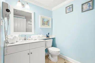 a bathroom with a toilet and a sink and a mirror at Beachfront, Ocean Views, Sleeps 6 , Hot tub in Panama City Beach