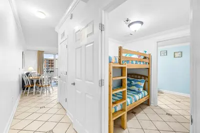 a bedroom with a bunk bed and a dining room at Beachfront, Ocean Views, Sleeps 6 , Hot tub in Panama City Beach