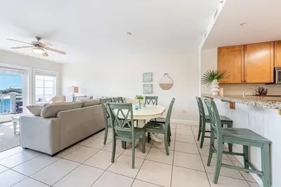 a kitchen and living room with a table and chairs at 402 Cassine Station - High Tide 30A in Santa Rosa Beach