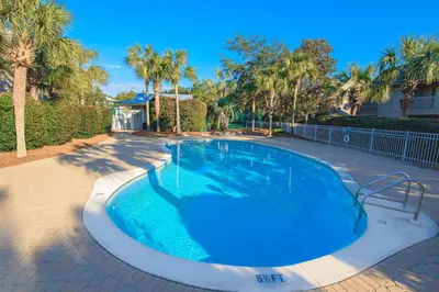 a large swimming pool in a yard with palm trees at 402 Cassine Station - High Tide 30A in Santa Rosa Beach