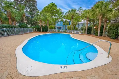 a swimming pool in a yard with palm trees at 402 Cassine Station - High Tide 30A in Santa Rosa Beach