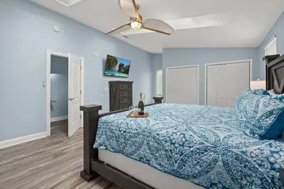 a bedroom with a bed and a ceiling fan at Latitude Adjustment - Private Pool, Game Room, Spacious Home, Pets OK, 5 Min Walk to Beach! in Panama City Beach