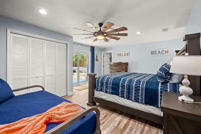 a bedroom with a bed and a ceiling fan at Latitude Adjustment - Private Pool, Game Room, Spacious Home, Pets OK, 5 Min Walk to Beach! in Panama City Beach