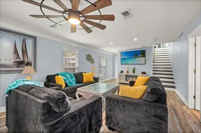 a living room with two couches and a ceiling fan at Latitude Adjustment - Private Pool, Game Room, Spacious Home, Pets OK, 5 Min Walk to Beach! in Panama City Beach