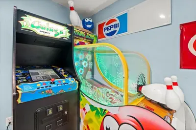 a pinball game in a childs room at Latitude Adjustment - Private Pool, Game Room, Spacious Home, Pets OK, 5 Min Walk to Beach! in Panama City Beach