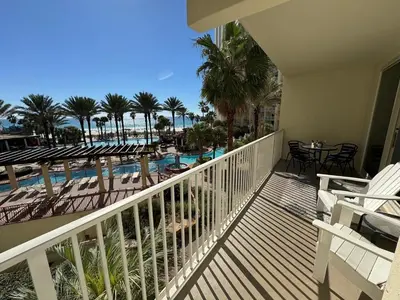 a balcony with a view of a pool and palm trees at SHORES of PANAMA 315 in Panama City Beach
