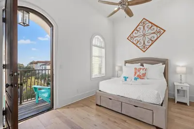 a bedroom with a bed and a balcony at Sea Esta Villa in Santa Rosa Beach