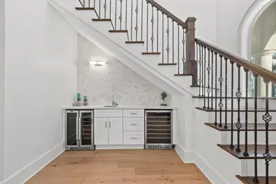 a kitchen with white cabinets and a staircase at Sea Esta Villa in Santa Rosa Beach