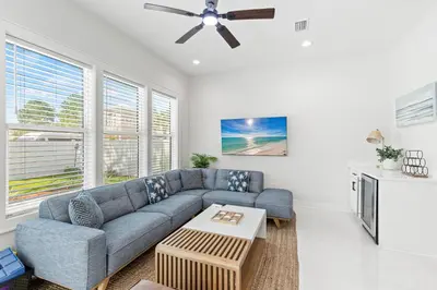 a living room with a blue couch and a ceiling fan at The Suite Life on 30A in Santa Rosa Beach