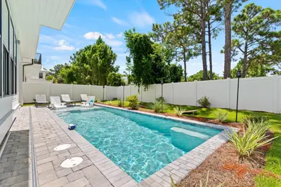 a swimming pool in a backyard with a fence at The Suite Life on 30A in Santa Rosa Beach