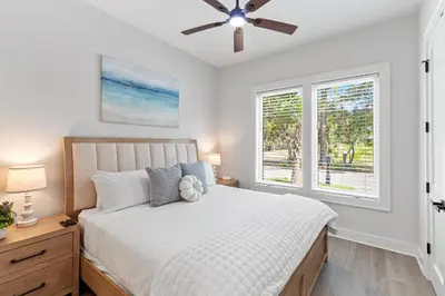 a bedroom with a bed with a ceiling fan at The Suite Life on 30A in Santa Rosa Beach