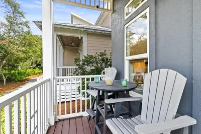 a patio with a table and chairs on a porch at Big Kahuna Beach House in Santa Rosa Beach