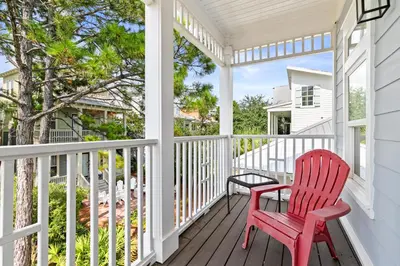 a red rocking chair sitting on a porch at Big Kahuna Beach House in Santa Rosa Beach