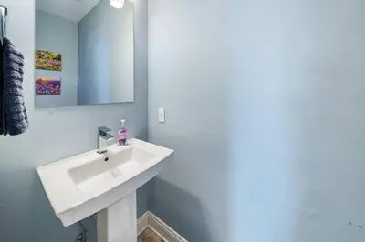 a bathroom with a white sink and a mirror at *NEW* Arcade Games & Steps to Beach! | 1800+ Sq Ft in Panama City Beach