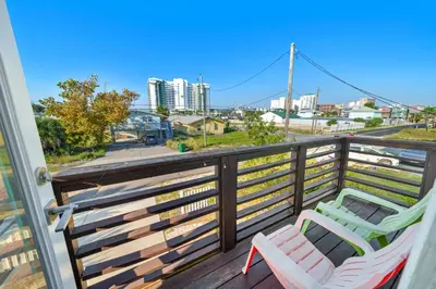 a balcony with two chairs and a view of a city at *NEW* Arcade Games & Steps to Beach! | 1800+ Sq Ft in Panama City Beach