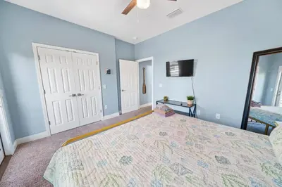 a bedroom with a large bed and a flat screen tv at *NEW* Arcade Games & Steps to Beach! | 1800+ Sq Ft in Panama City Beach