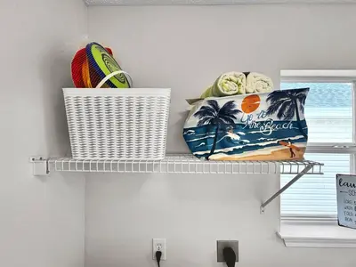 a shelf with a basket and a bag on it at 1.2 mi to Beach | 15min to Pier Park | Pool Access in Panama City Beach