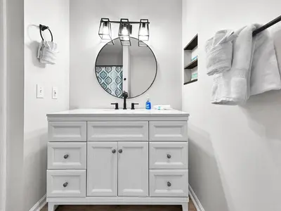 a white bathroom with a sink and a mirror at 1.2 mi to Beach | 15min to Pier Park | Pool Access in Panama City Beach