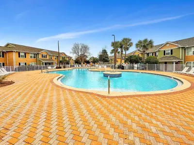 a large swimming pool in a yard with houses at Kid's Playground & Pool! | Spring Getaway! in Panama City Beach