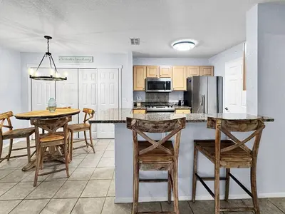 a kitchen with a table and chairs and a refrigerator at Kid's Playground & Pool! | Spring Getaway! in Panama City Beach