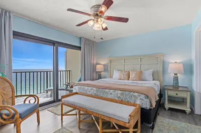a bedroom with a bed and a balcony at Commodore 1306 in Panama City Beach