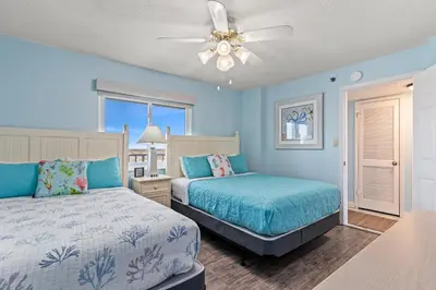 a bedroom with two beds and a ceiling fan at Commodore 1306 in Panama City Beach