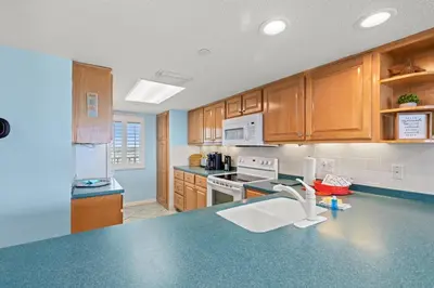 a kitchen with a blue counter top with a sink at Commodore 1306 in Panama City Beach