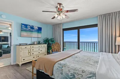 a bedroom with a bed and a view of the ocean at Commodore 1306 in Panama City Beach
