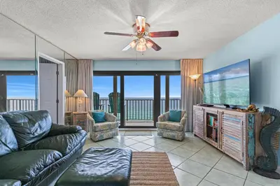a living room with a couch and a flat screen tv at Commodore 1306 in Panama City Beach
