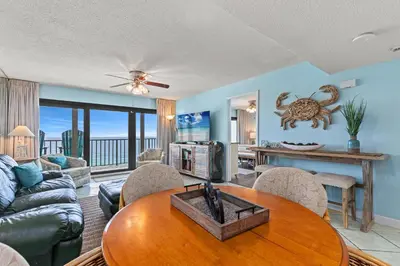 a living room with a table and a couch at Commodore 1306 in Panama City Beach