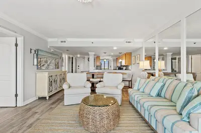 a living room with a couch and chairs and a kitchen at Commodore 1106 in Panama City Beach