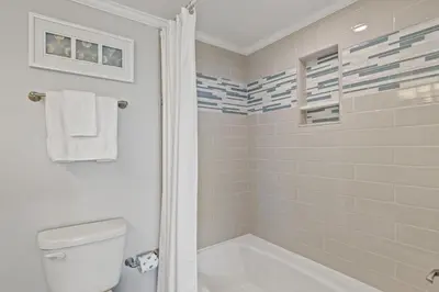 a bathroom with a tub and a toilet and a shower at Commodore 1106 in Panama City Beach