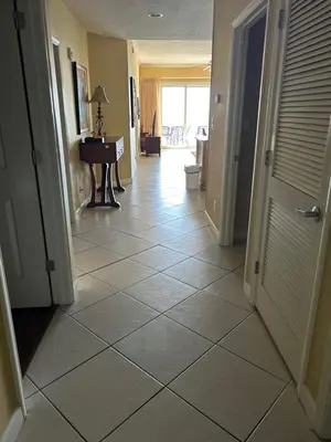 a hallway with a large tiled floor with a door at Grandview East in Panama City Beach