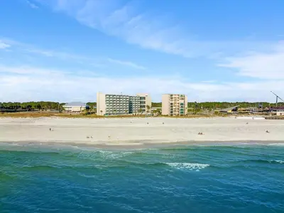 a beach with buildings in the background and the ocean at Beach Front Ocean View Condo - Top of the Gulf 615 in Panama City Beach