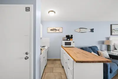 a kitchen with a counter and a blue couch at Beach Front Ocean View Condo - Top of the Gulf 615 in Panama City Beach