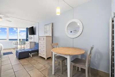 a dining room with a table and a mirror at Beach Front Ocean View Condo - Top of the Gulf 615 in Panama City Beach