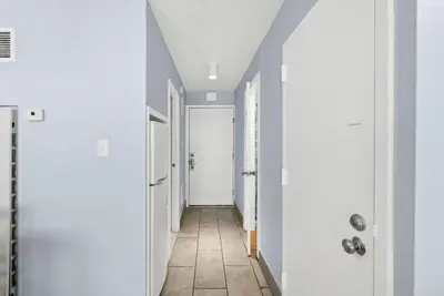 a hallway with blue walls and a white door at Beach Front Ocean View Condo - Top of the Gulf 615 in Panama City Beach