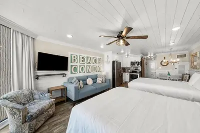 a bedroom with two beds and a living room at Beachfront Studio Condo - Top of the Gulf 317 in Panama City Beach