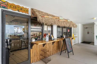 a restaurant with a bar with a sign in front of it at It Doesn’t Get Any Better Than This! 2BR 2BA Sleeps 8 Beachfront! in Panama City Beach