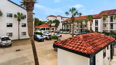 an apartment complex with cars parked in a parking lot at Palms B4 in Santa Rosa Beach
