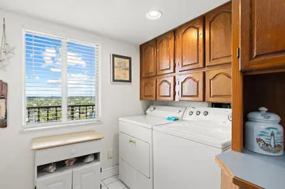 a kitchen with a washer and dryer and a window at Commodore 0608 in Panama City Beach