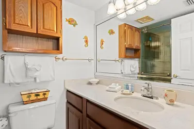 a bathroom with a sink and a toilet and a mirror at Commodore 0608 in Panama City Beach