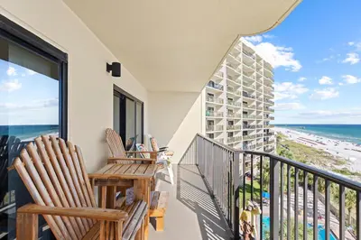 a balcony with two chairs and a view of the beach at Commodore 0608 in Panama City Beach
