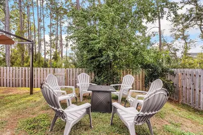 a group of chairs and a table in a yard at Sunny Daze by Emerald Coast Retreats in Panama City Beach