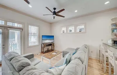 a living room with a couch and a flat screen tv at Blue Lagoon by Emerald Coast Retreats in Panama City Beach