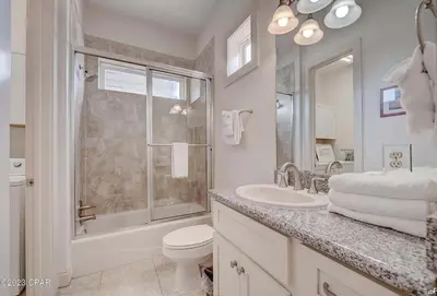 a white bathroom with a toilet and a sink at Blue Lagoon by Emerald Coast Retreats in Panama City Beach