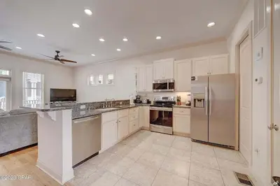 a large kitchen with white cabinets and stainless steel appliances at Blue Lagoon by Emerald Coast Retreats in Panama City Beach