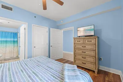 a bedroom with a bed and a television on a dresser at Bright & Spacious Condo 1BD! Steps from the Beach! by Dolce Vita Getaways PCB in Panama City Beach